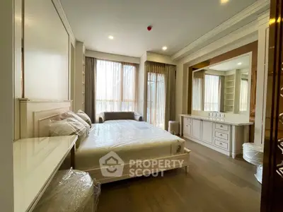 Luxurious bedroom with elegant furnishings and large windows for natural light.