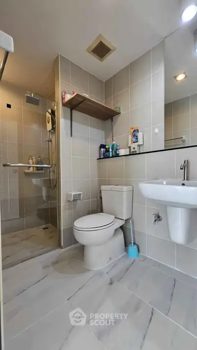 Modern bathroom with sleek fixtures and spacious shower area in a contemporary home.