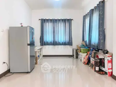 Spacious room with fridge and storage boxes, ideal for versatile use.