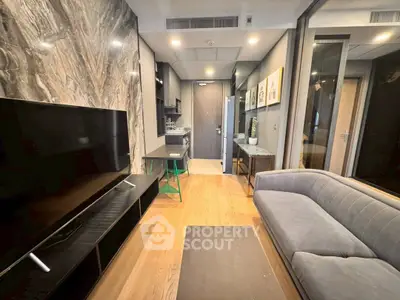 Modern living room with sleek design and open layout, featuring a large TV and stylish sofa.