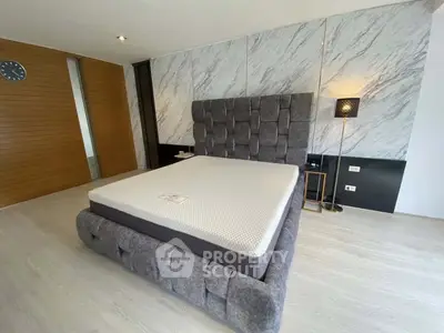 Luxurious modern bedroom with stylish decor and plush bed in a contemporary setting.