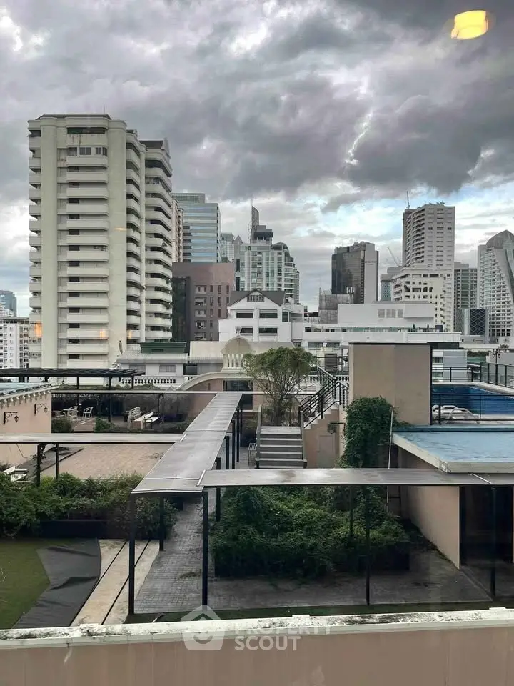 Stunning cityscape view from a rooftop terrace with lush greenery and modern architecture.