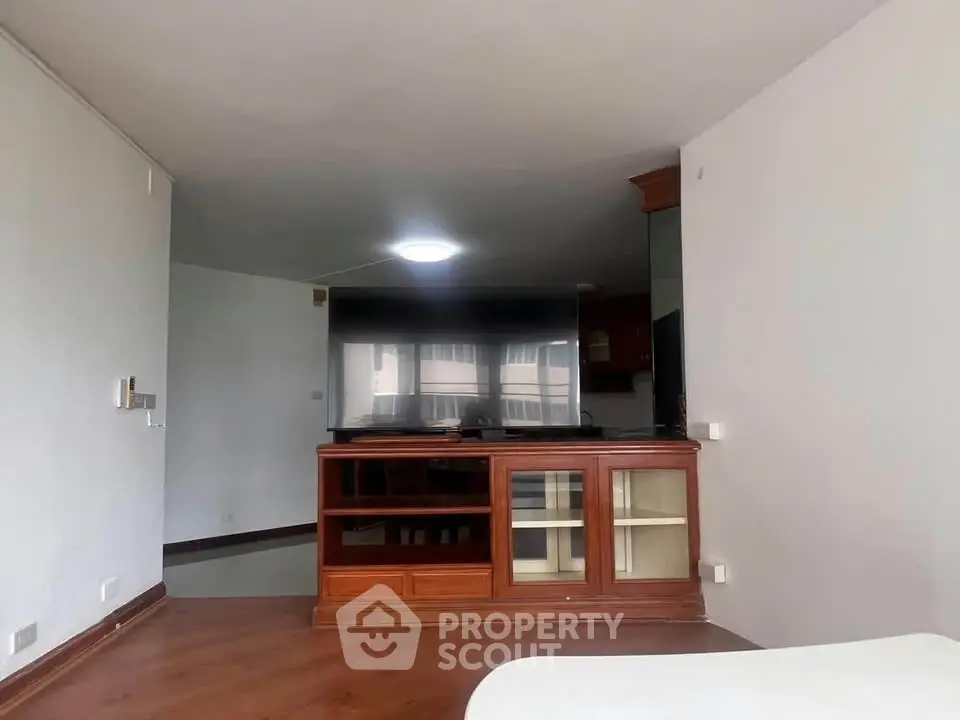 Spacious living area with wooden flooring and built-in cabinetry, ideal for modern living.