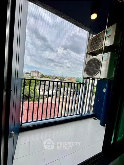 Charming balcony with city view and air conditioning units, perfect for relaxation.