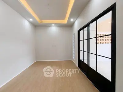 Spacious modern room with elegant lighting and sliding glass doors, perfect for versatile living or office space.