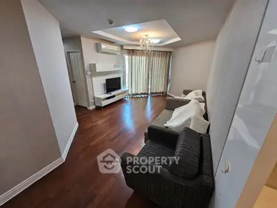 Spacious living room with hardwood floors, modern lighting, and cozy seating area.