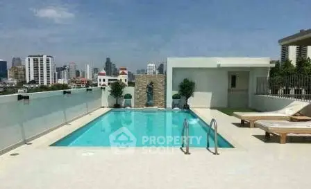 Luxurious rooftop pool with city skyline views in modern apartment complex.