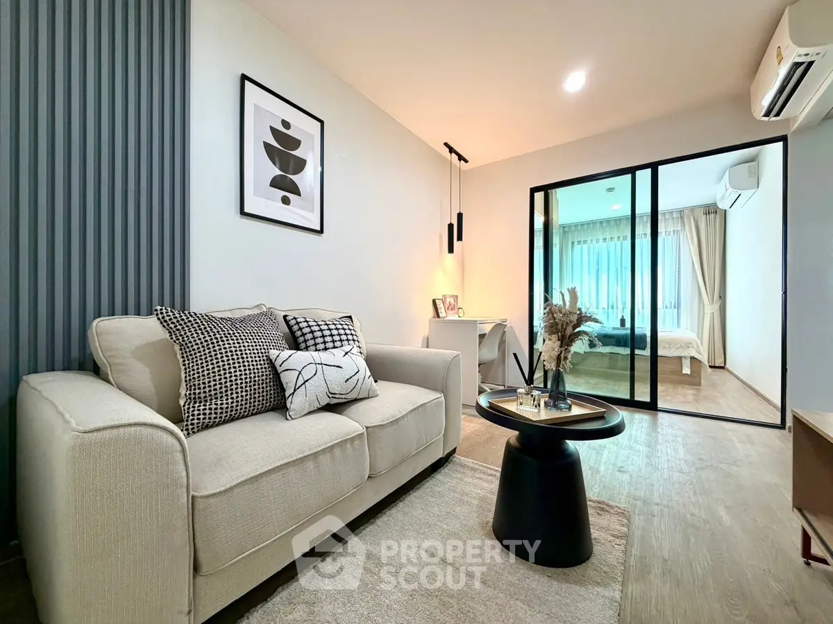 Modern living room with stylish decor and view into cozy bedroom