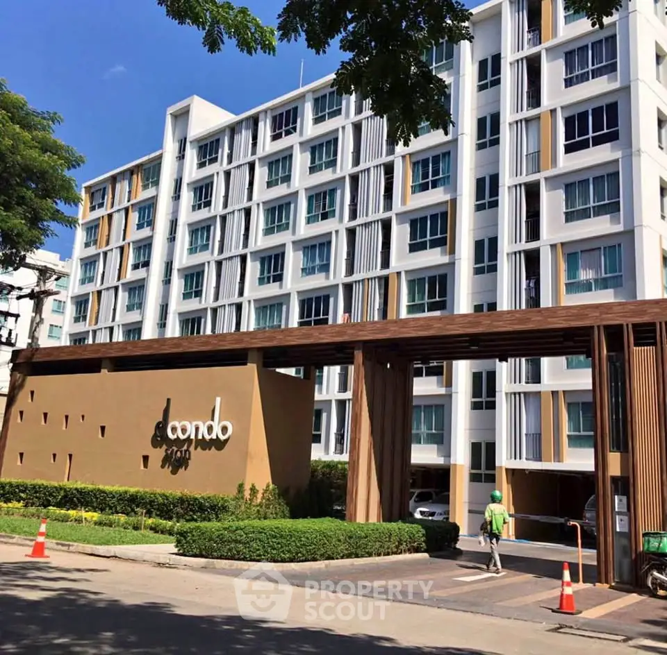 Modern condo building exterior with lush landscaping and stylish entrance.