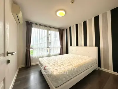 Modern bedroom with striped accent wall and large window