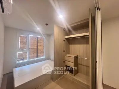 Modern bedroom with built-in wardrobe and large window, perfect for urban living.