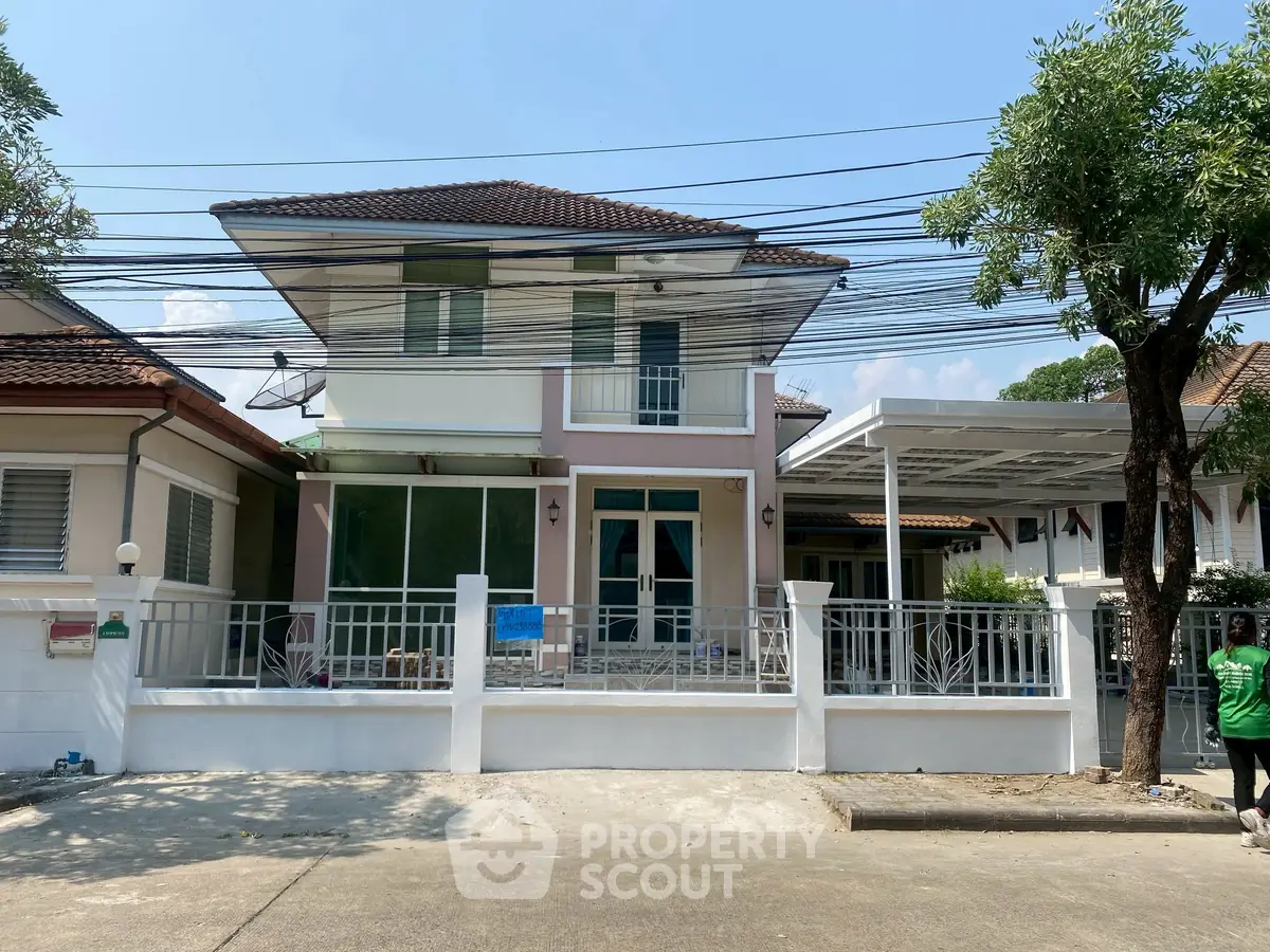 Charming two-story house with gated front yard and carport in suburban neighborhood.