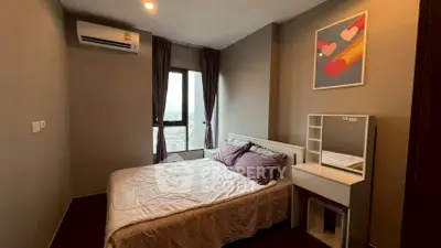 Cozy bedroom with modern decor and city view, featuring a stylish vanity and air conditioning.
