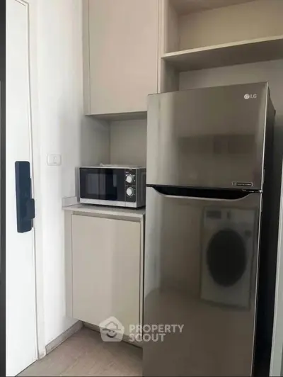 Modern kitchen corner with stainless steel fridge and microwave