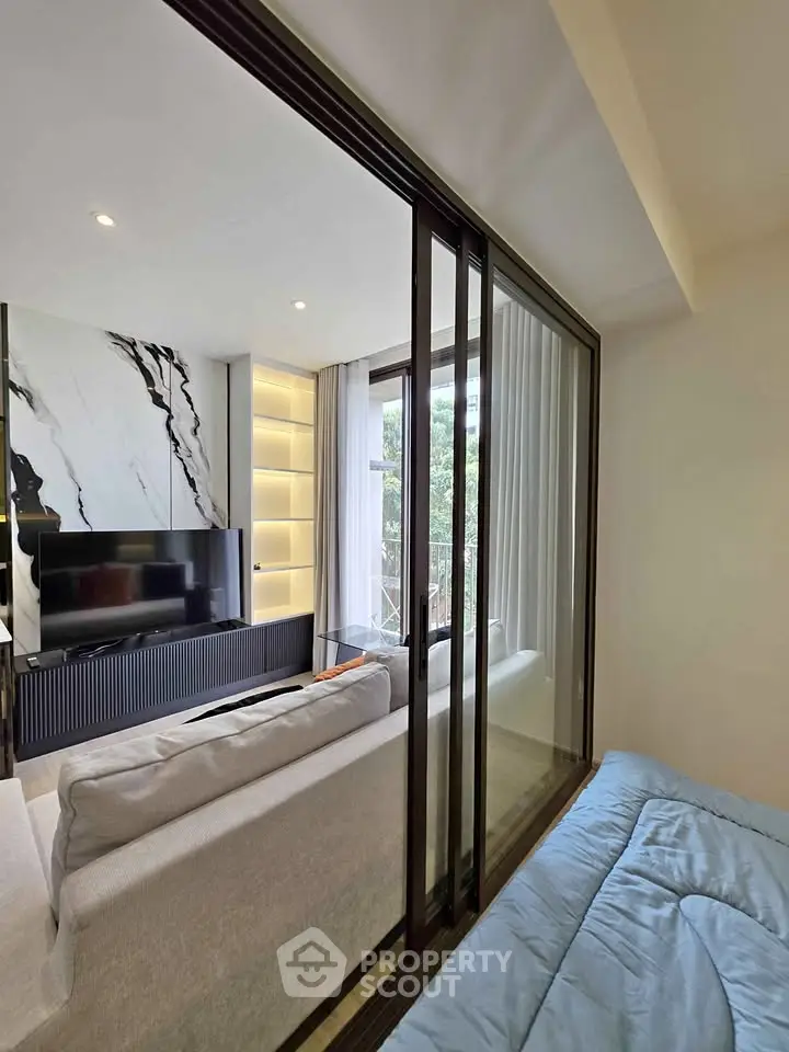Modern living room with sliding glass doors and stylish marble accent wall