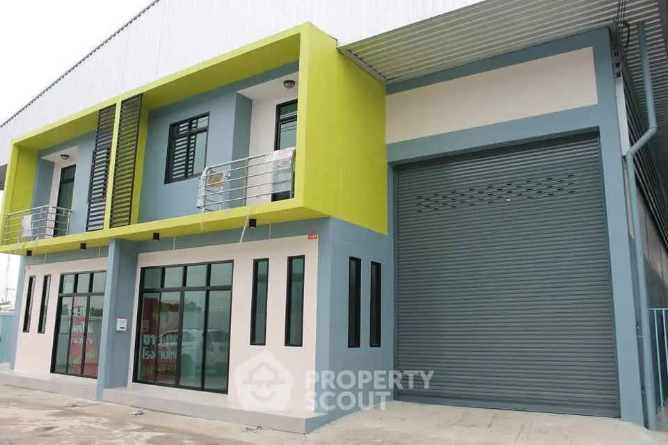 Modern commercial building with vibrant facade and large garage door, ideal for business operations.
