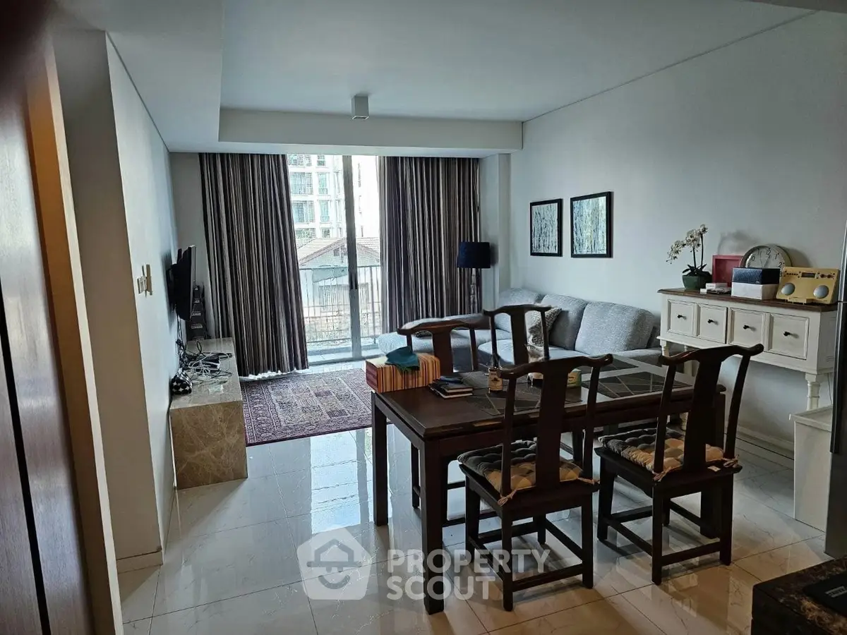 Spacious living room with modern decor and large window view in a stylish apartment.