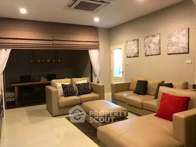 Luxurious living room with elegant beige sofas and modern decor, perfect for relaxation and entertainment.