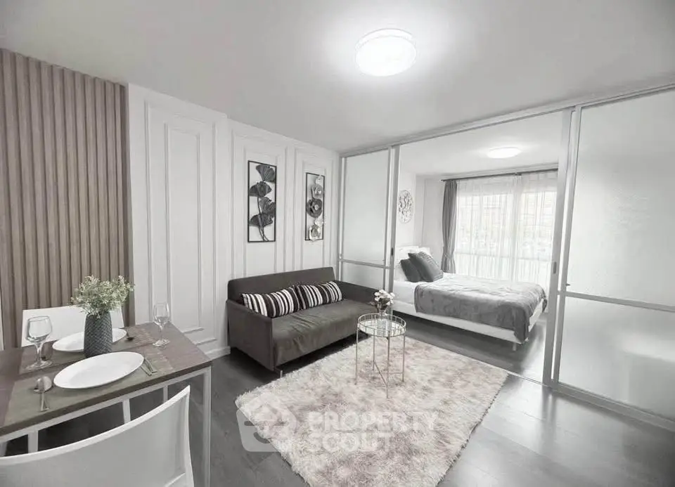 Modern open-plan living room with stylish decor and cozy bedroom area