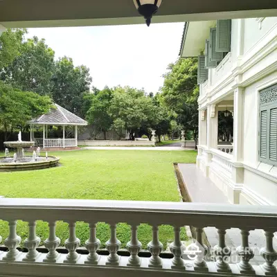 Elegant colonial-style home with lush garden and charming gazebo, perfect for serene living.