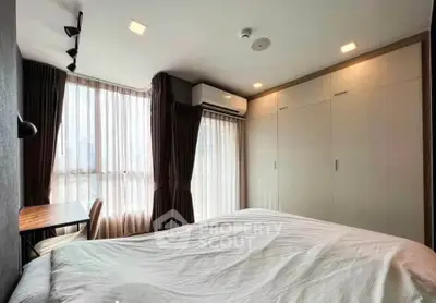 Modern bedroom with large windows and built-in wardrobe, featuring a cozy workspace.