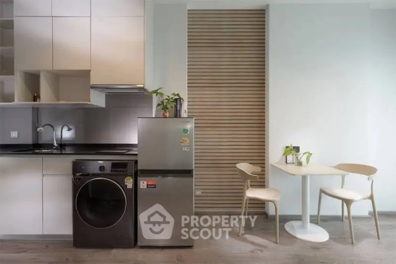 Modern kitchen with sleek appliances and cozy dining area, perfect for urban living.