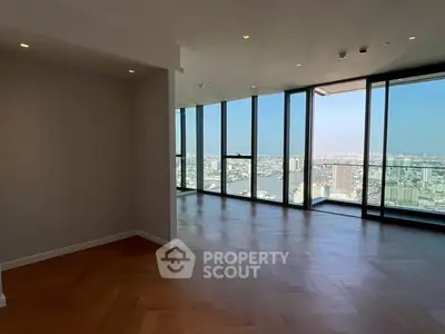 Spacious modern living room with panoramic city view and elegant wooden flooring.
