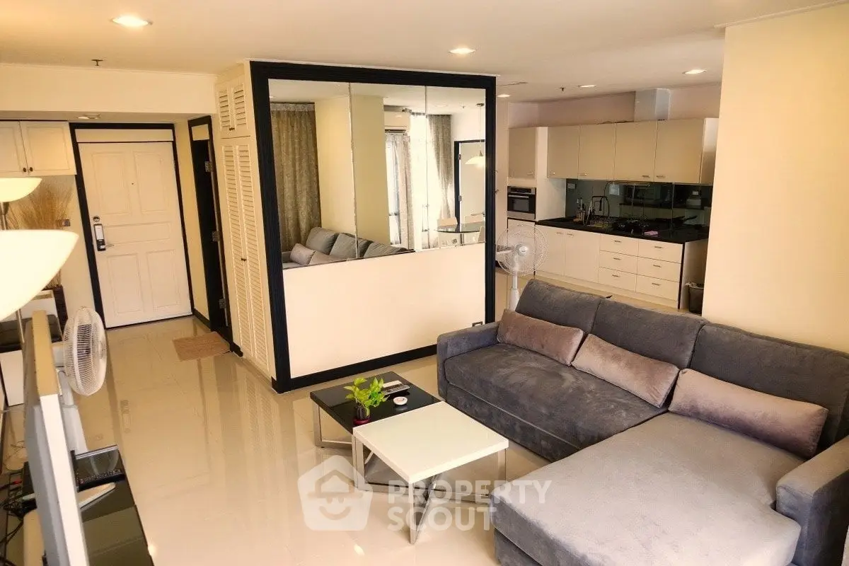 Modern living room with sleek design and open kitchen layout in a stylish apartment.