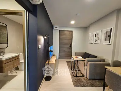 Modern living room with cozy sofa and stylish decor adjacent to a sleek bathroom.