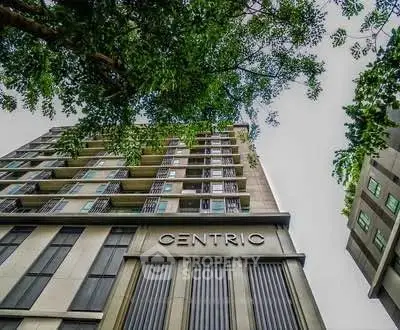 Modern high-rise building with lush greenery and sleek architectural design.