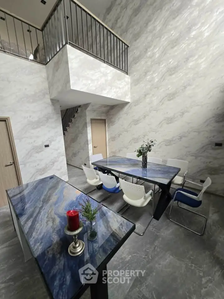 Modern dining area with elegant marble walls and stylish blue stone table.