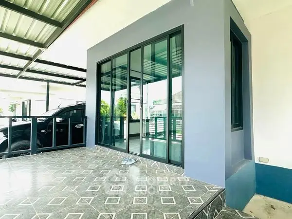 Modern home exterior with sleek sliding glass doors and covered patio.