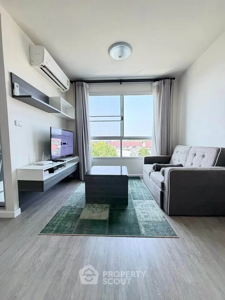 Modern living room with stylish furniture and large window offering a scenic view.