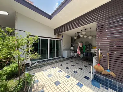 Charming outdoor patio with tiled flooring and garden view, perfect for relaxation and entertaining.
