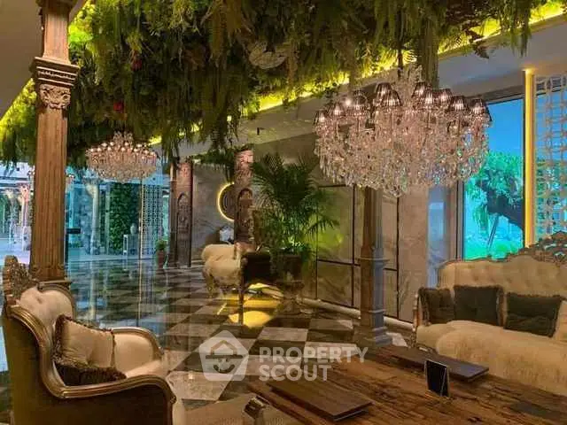 Luxurious living room with opulent chandeliers and lush greenery decor.