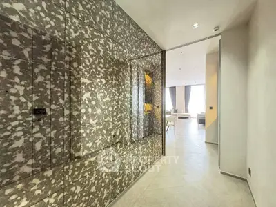 Luxurious modern hallway leading to a spacious living room with elegant decor and large windows.