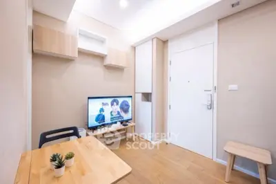 Cozy modern living room with TV and wooden furniture, perfect for relaxation.