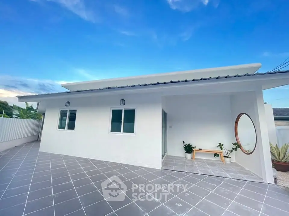 Modern single-story home with spacious tiled patio and minimalist design.