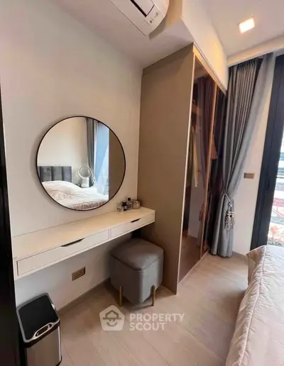 Modern bedroom with stylish vanity and large mirror, featuring elegant curtains and a cozy atmosphere.