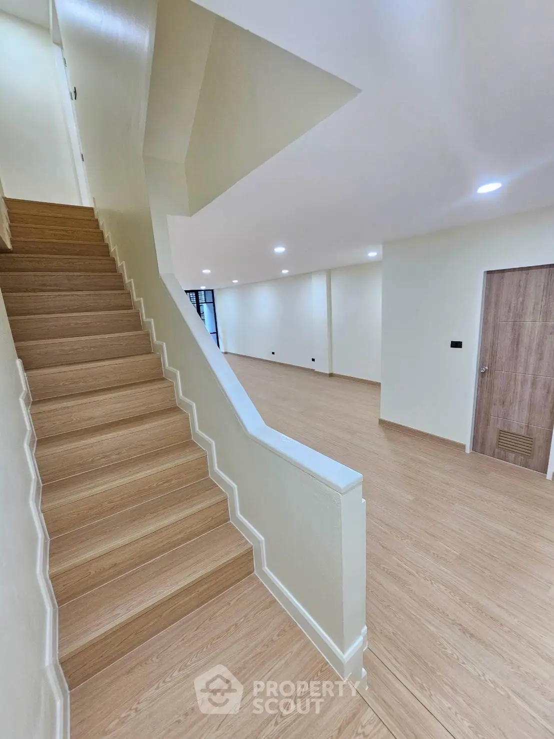 Spacious modern interior with wooden staircase and open living area, perfect for contemporary living.