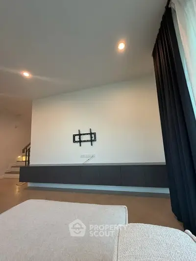 Modern living room with wall-mounted TV bracket and sleek cabinetry