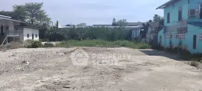 Vacant land plot ideal for development in a residential area with nearby buildings.