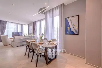 Luxurious open-plan living and dining area with elegant decor and large windows.