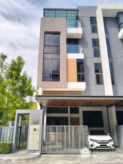 Modern multi-story townhouse with sleek design and gated entrance