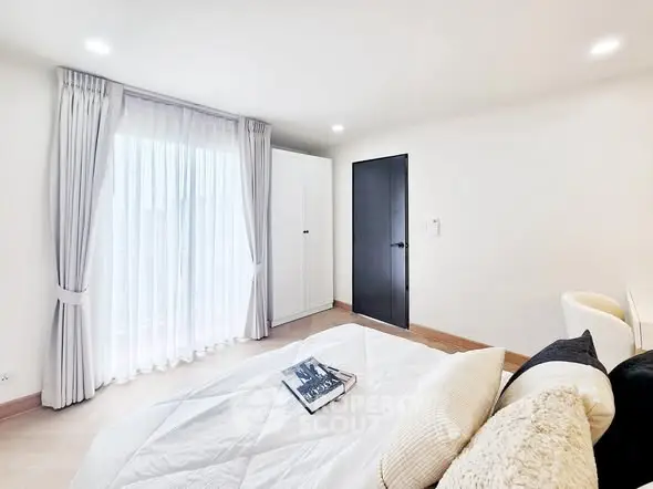 Bright and airy bedroom with modern decor and large window for natural light.