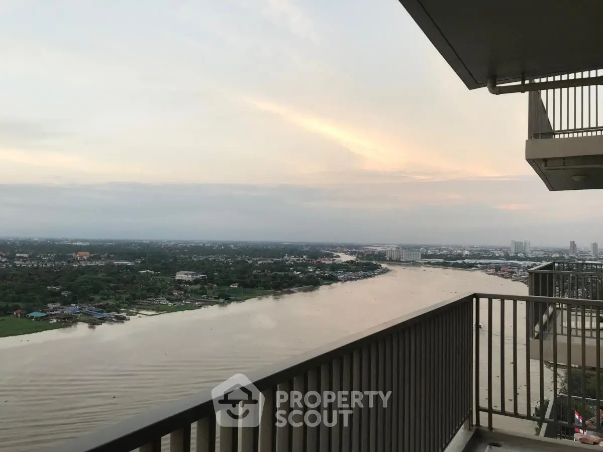 Stunning river view from high-rise balcony at sunset, perfect for relaxation.