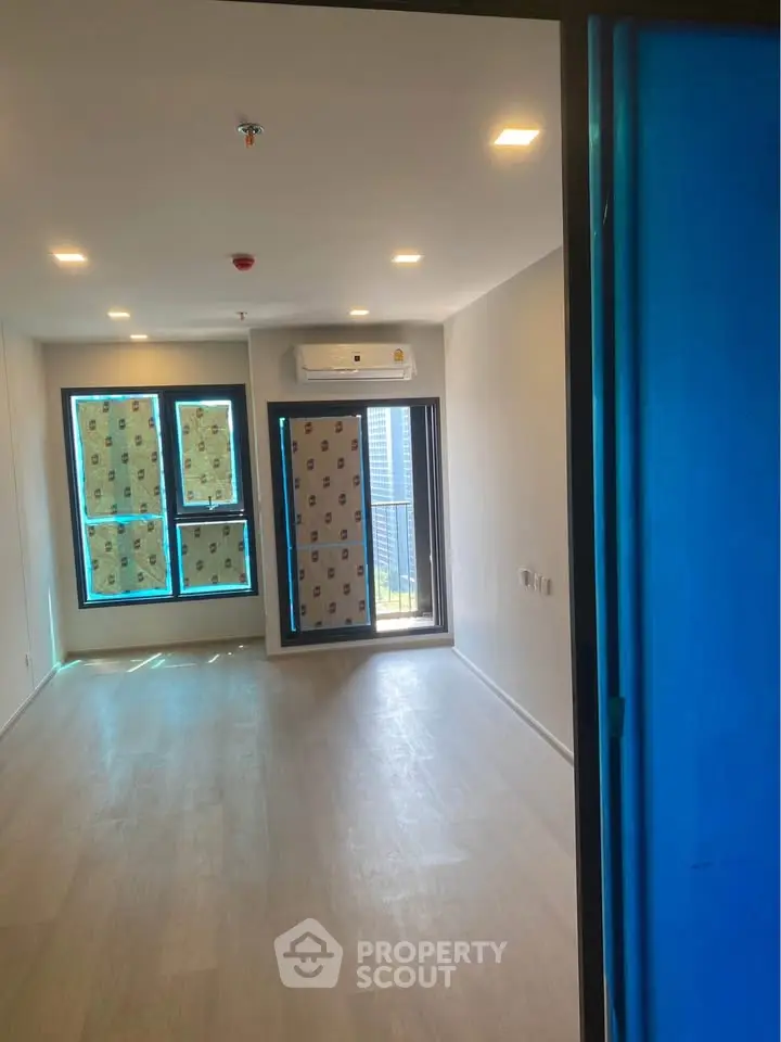 Spacious unfurnished living room with large windows and modern lighting