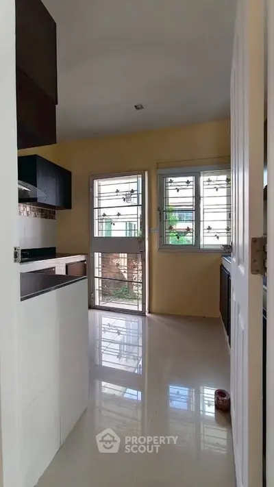 Modern kitchen with sleek cabinetry and large windows offering ample natural light.