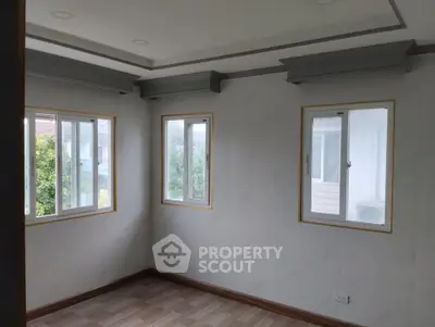Bright and airy room with large windows and elegant crown molding, perfect for a cozy living space.