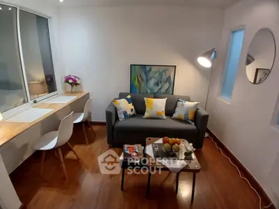 Charming living room with modern decor, cozy sofa, and stylish workspace in a bright apartment.